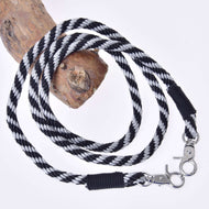 LarDen Hobby Horse Reins Black Stripe, twisted black and silver rope reins with silver snap hooks draped over a wooden branch