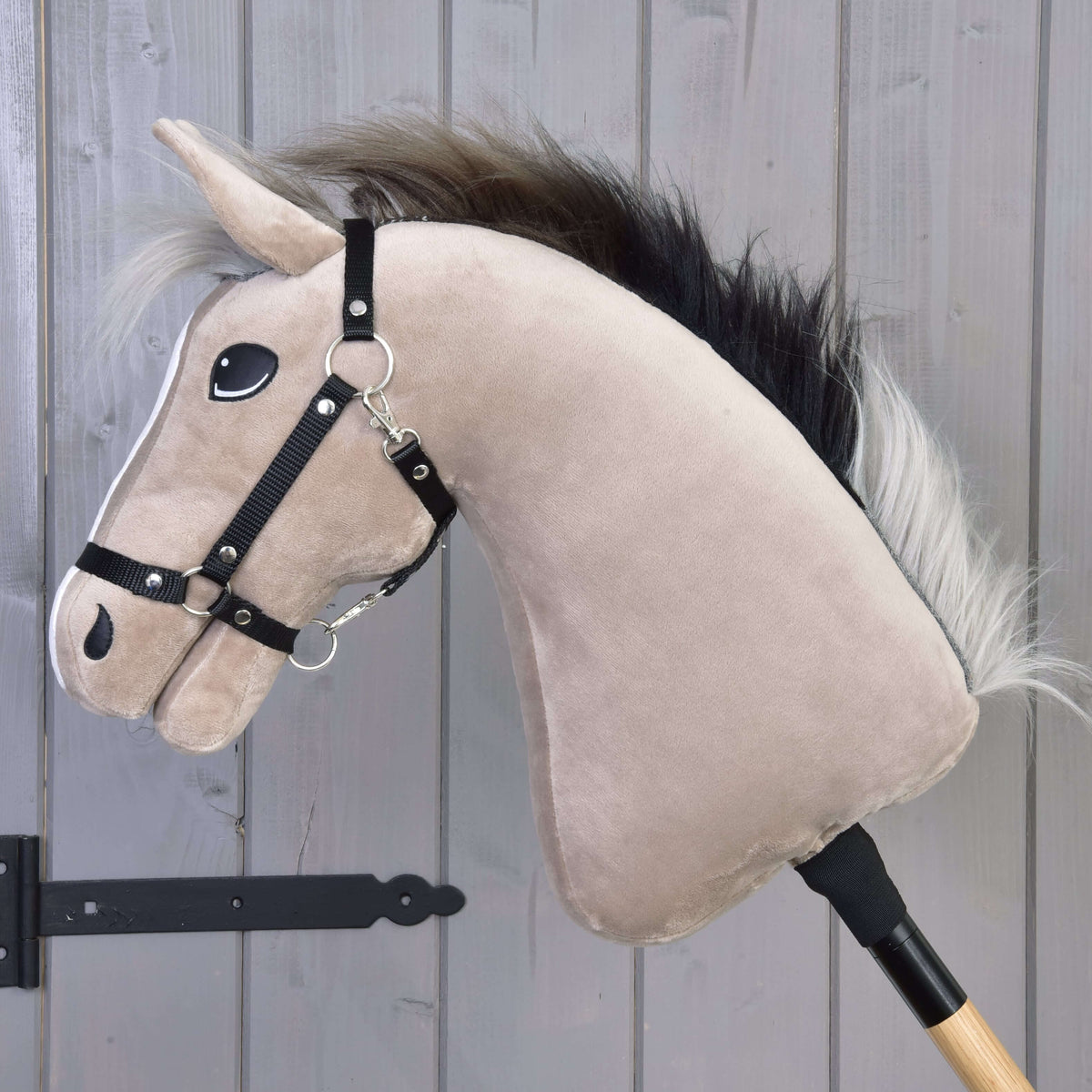 Hobby Horse Piccolino i vänsterprofil, som visar den gråbeige halsen, svart grimma och den mörka manen med silverfärgade toppar