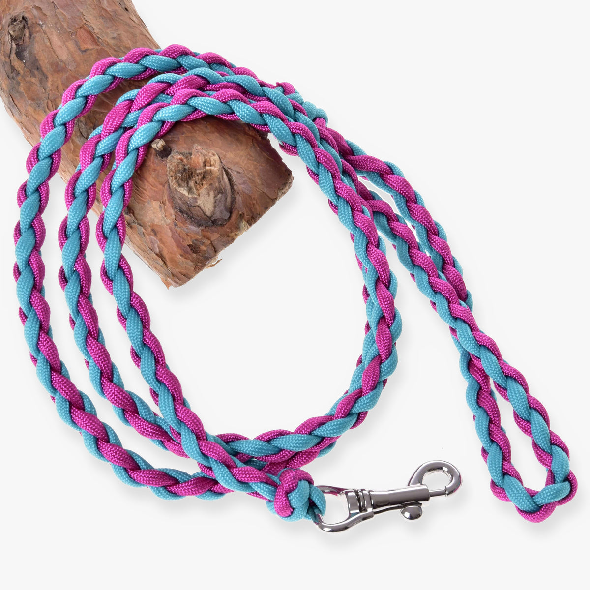 LarDen Hobby Horse Knitted Lead Rope Pinkie-Blue, braided paracord lead with silver snap hook coiled on a wooden log