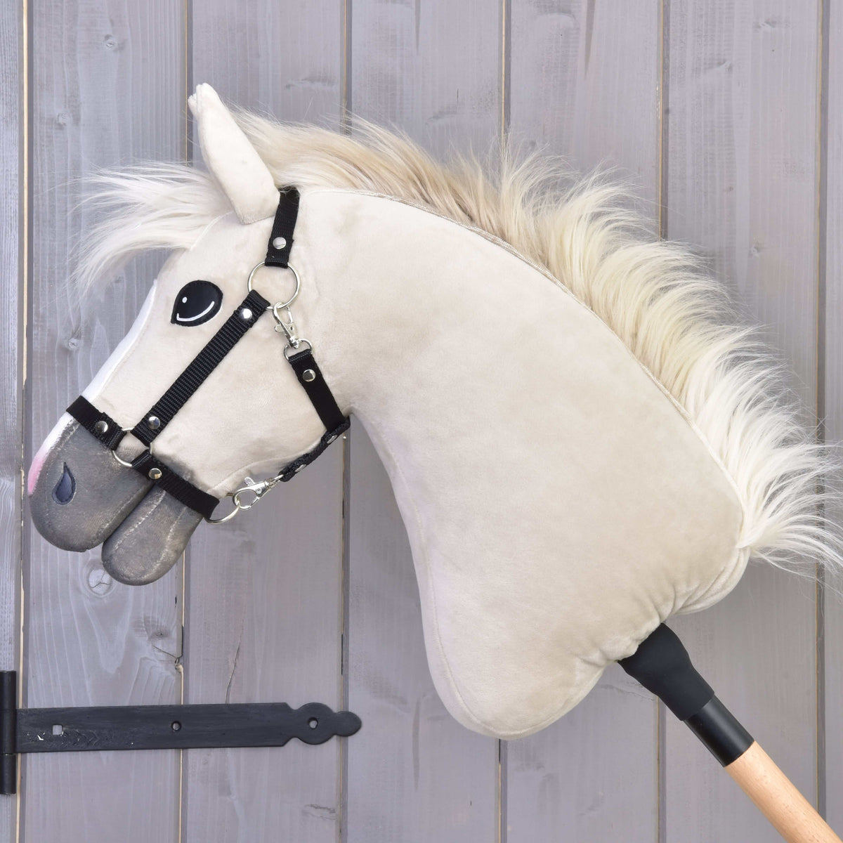 Hobby Horse Pixie in left profile with a silky cream fur mane, black halter and a shimmering grey muzzle