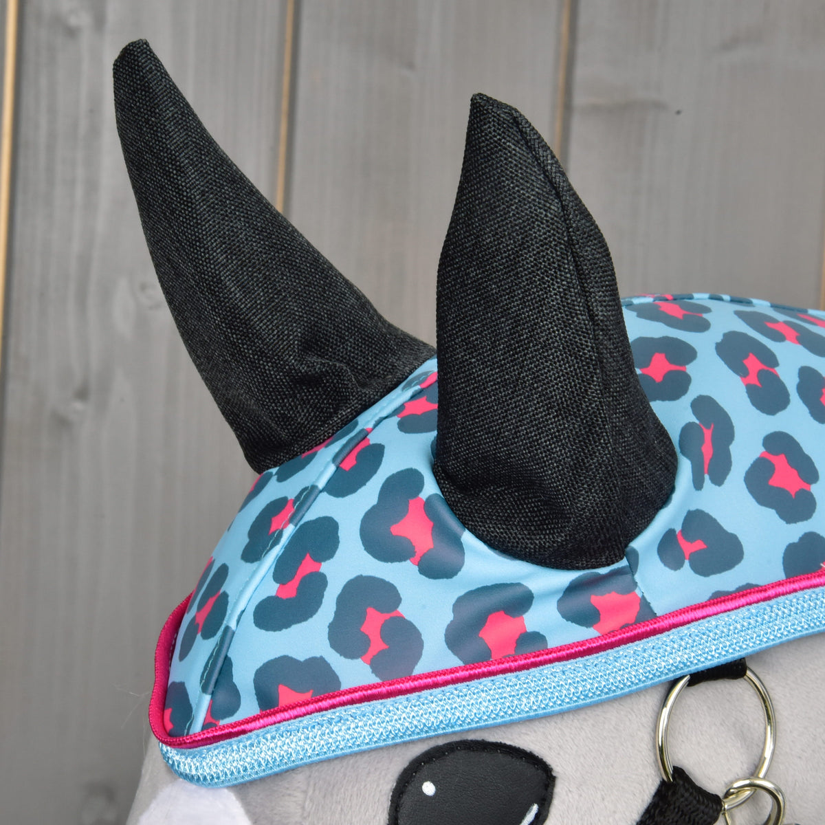 Close-up of the charcoal ears on the hood with its blue and pink leopard spots and pink-piped trim