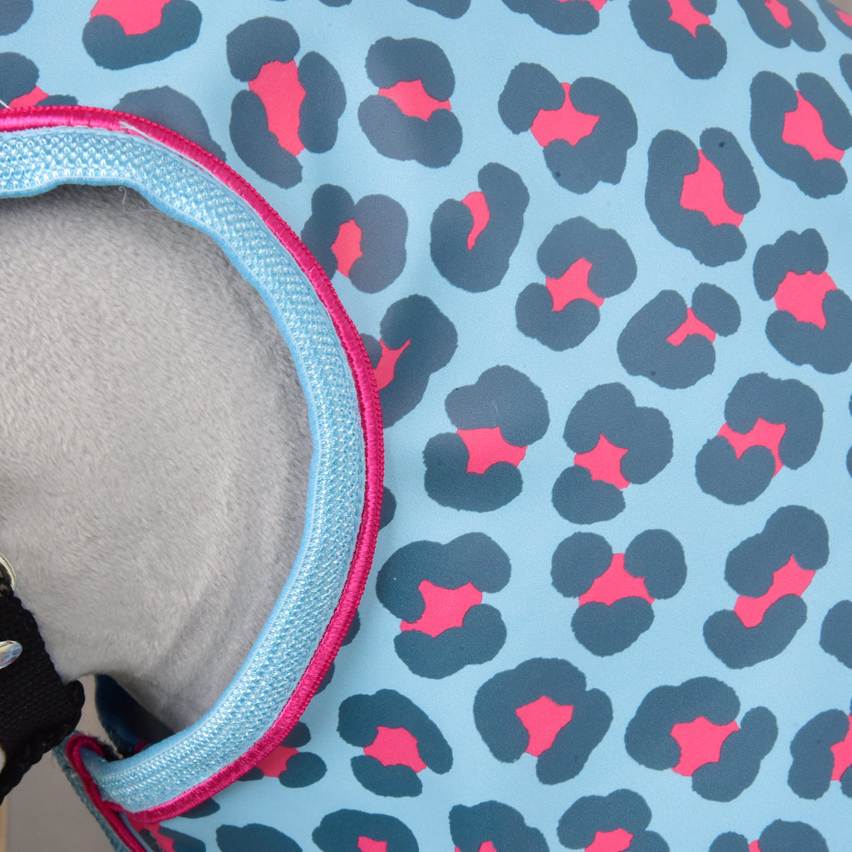 Close-up of the light blue leopard print fabric and the pink-piped edge around the face opening over grey plush