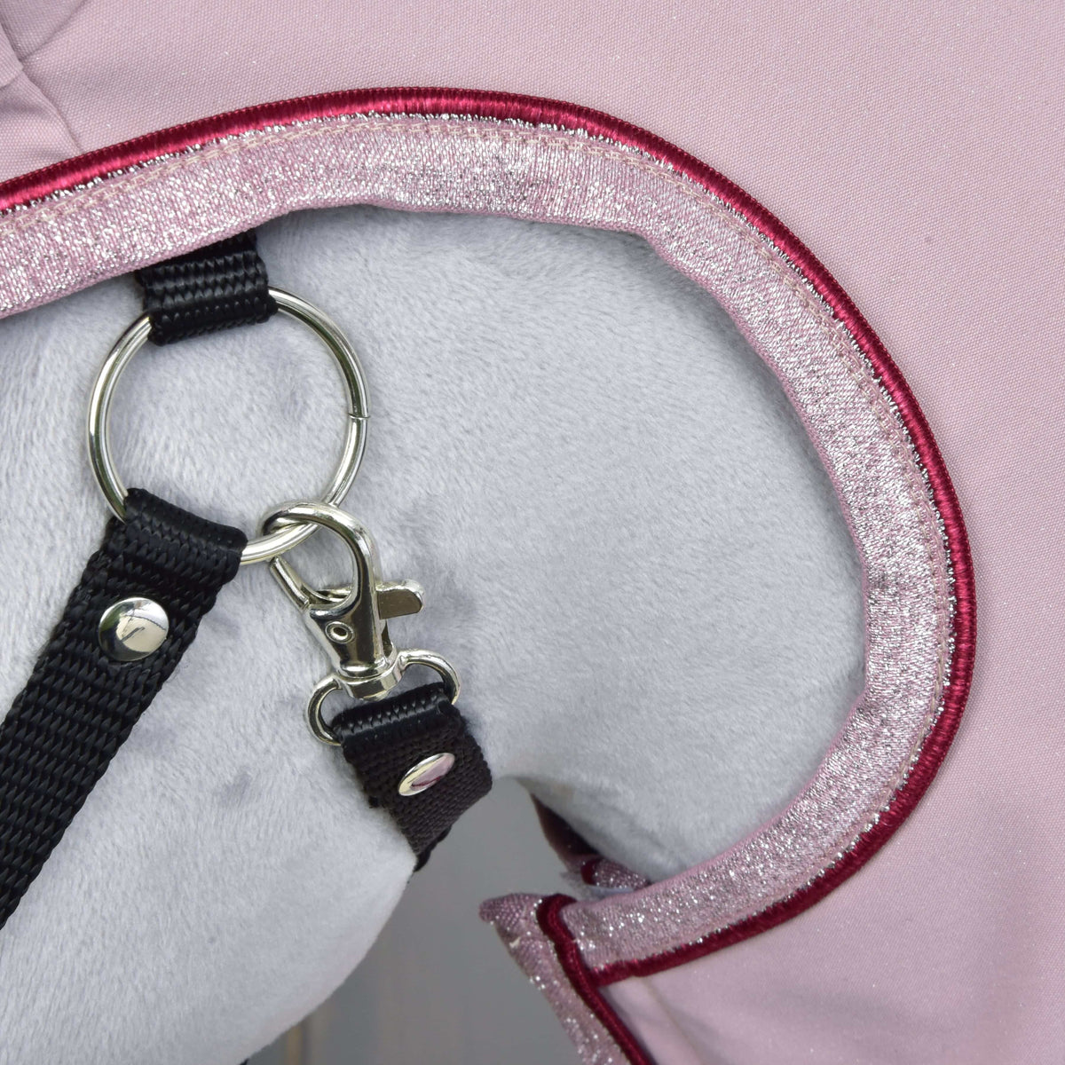 Close-up of the pink glitter binding and burgundy piping around the face opening, with a black halter ring and clip