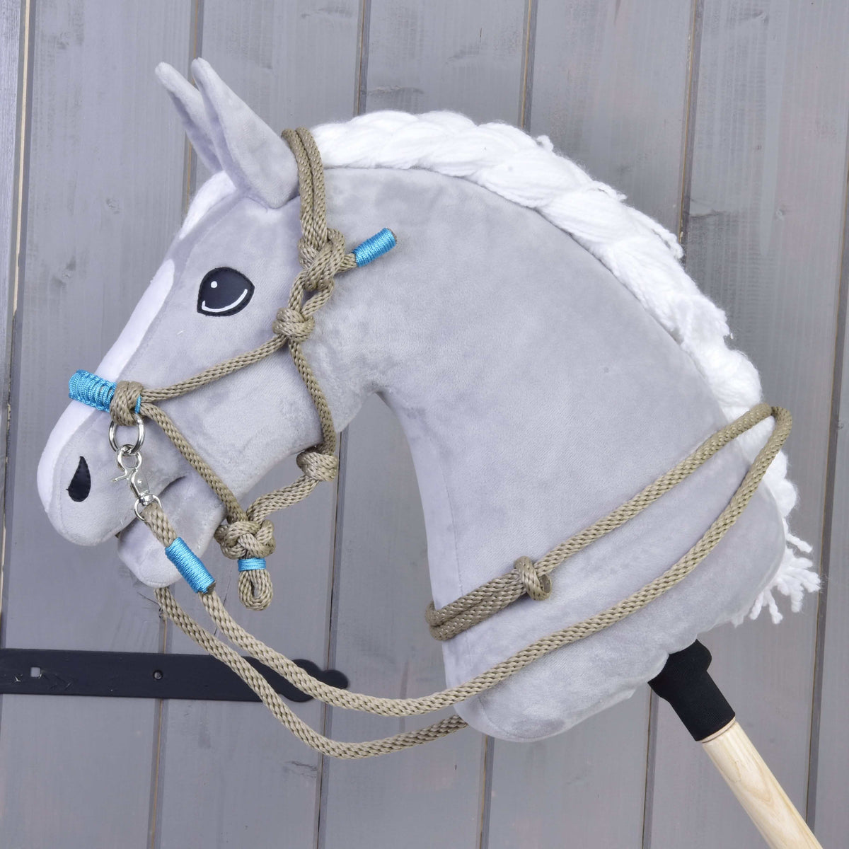 Grå käpphäst med vit flätad man i repset Nature Blue: beige repgrimma med blå lindningar och tyglar