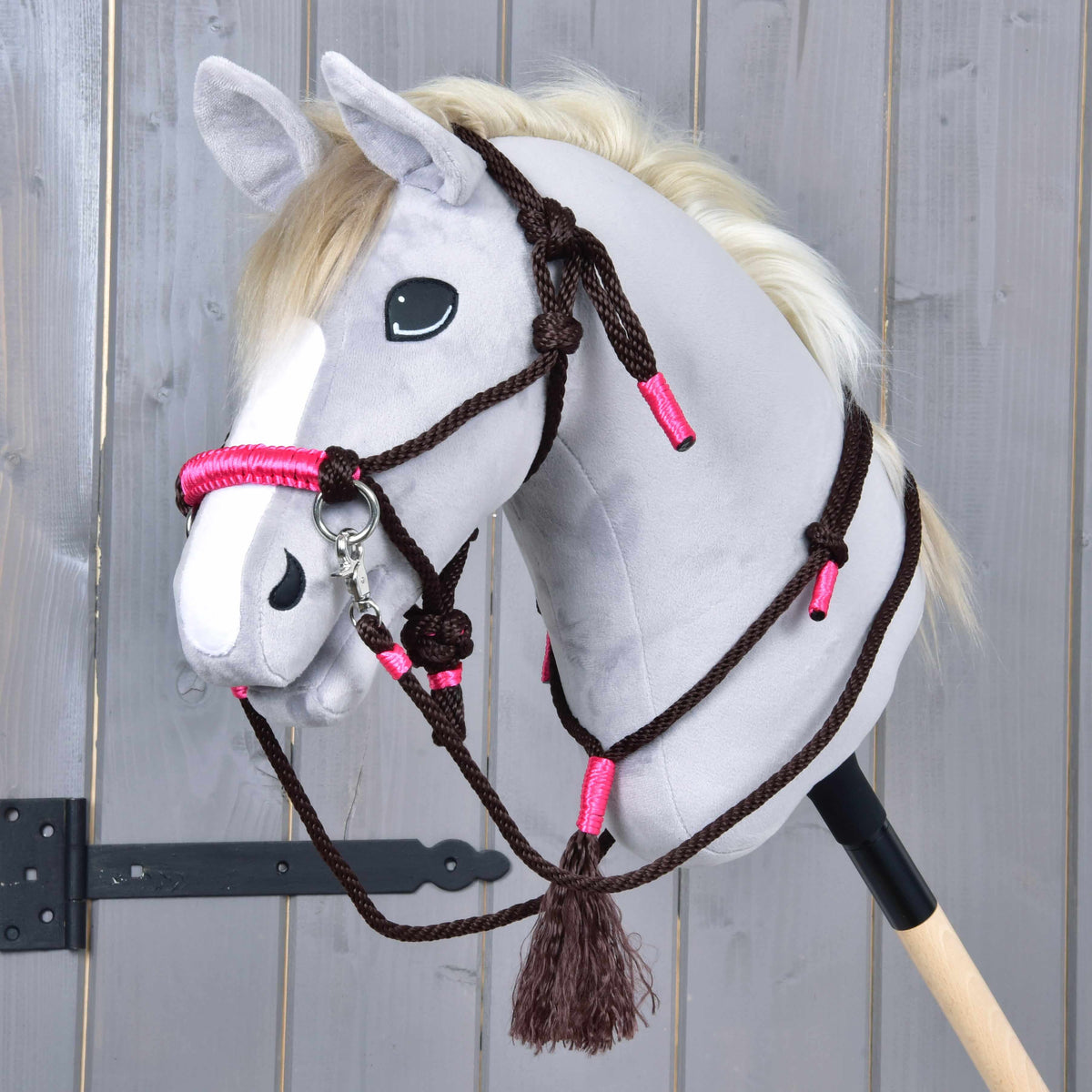 Grå käpphäst med repset Noir Cocoa: mörkbrun repgrimma med rosa nosrem, tyglar och en halsring med tofs