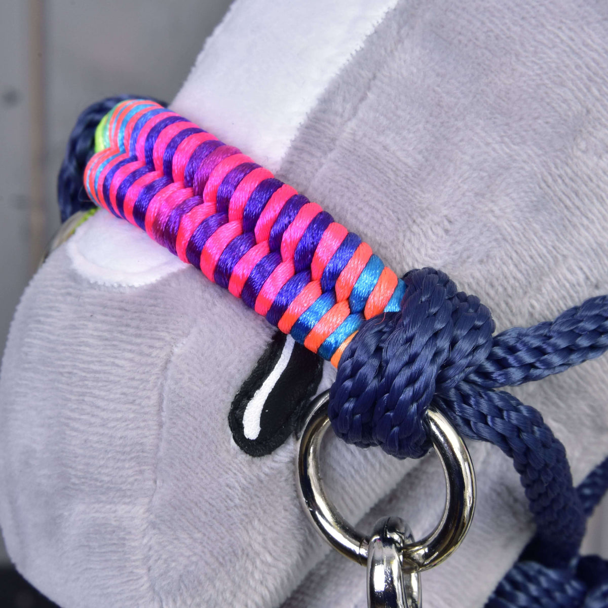 Makrodetalj av den flätade neonfärgade nosremmen på Hobby Horse repset Rosemary med marinblå repknut och silverfärgad ring