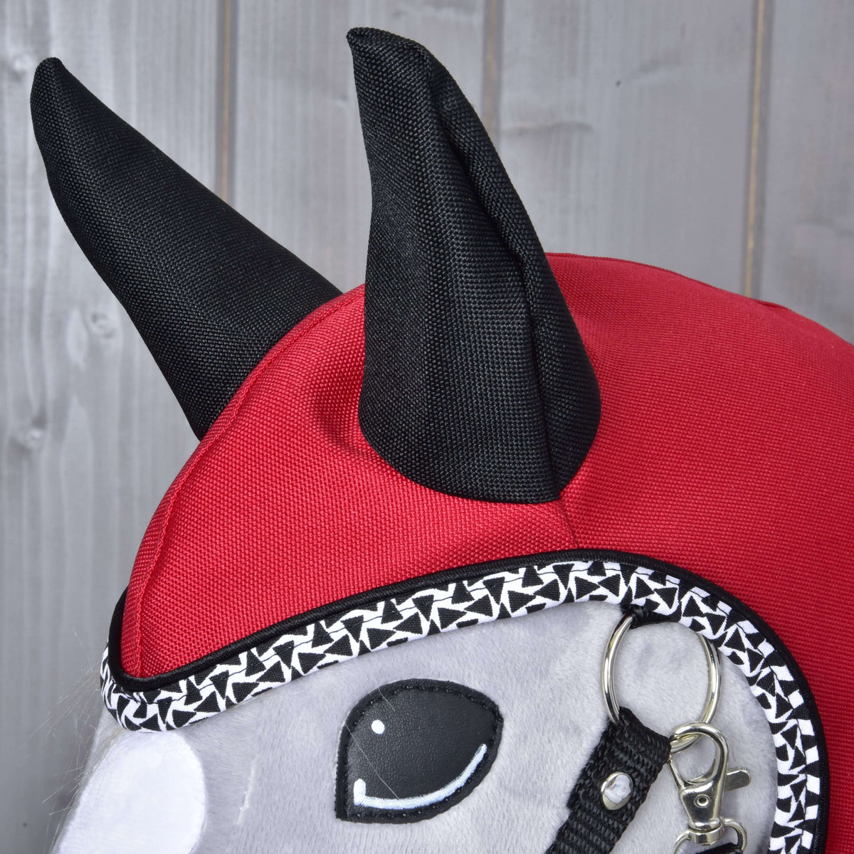 Close-up of the Raincoat Red Ferrari on a grey Hobby Horse: black fabric ears on the red hood and black and white trim