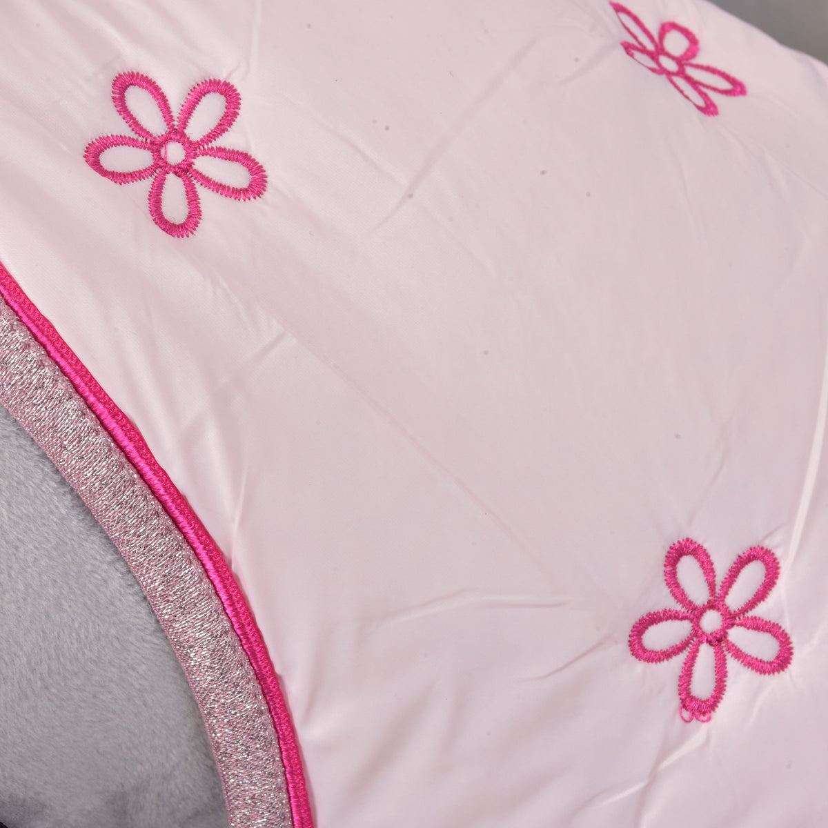 Detalj av de broderade rosa blommorna, rosa passpoal och glittrande kant på det ljusrosa stalltäcket Rosy till Hobby Horse