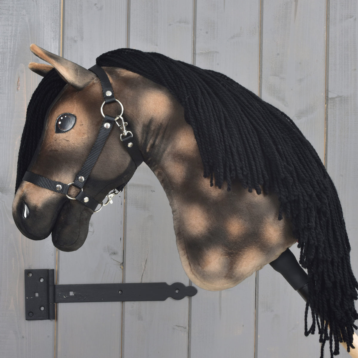 Hobby Horse Stormy med svart grimma vänd åt vänster, lång svart man av garn över den apelkastade halsen ner till käppen