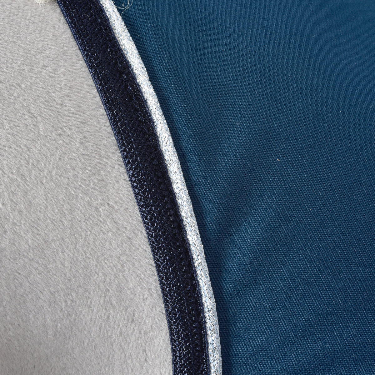 Macro of the navy binding and silver glitter piping along the petrol blue fabric of the Hobby Horse Stable Blanket Winter Sky