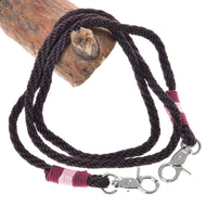 Hobby Horse Reins York by LarDen, dark brown rope reins with pink and burgundy wrapped ends and snap hooks, on a branch