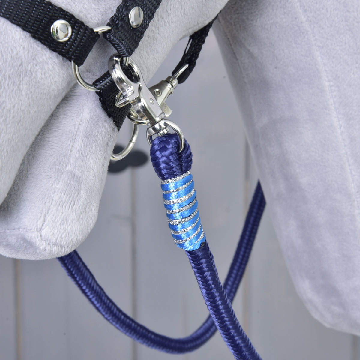 Close-up of the Hobby Horse Reins Blues light blue and silver wrap and snap hook on the black halter