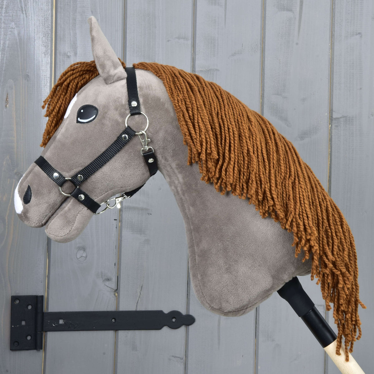 Hobby Horse Chanell in left profile with the long ginger yarn mane hanging down the grey-brown neck