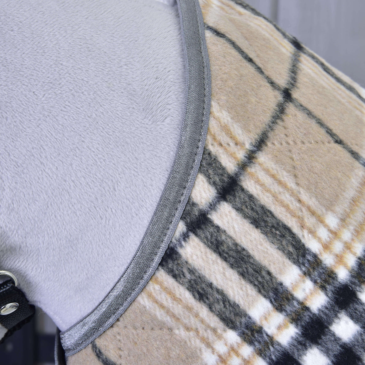 Close-up of the soft beige check fabric and grey binding at the neckline on a grey Hobby Horse