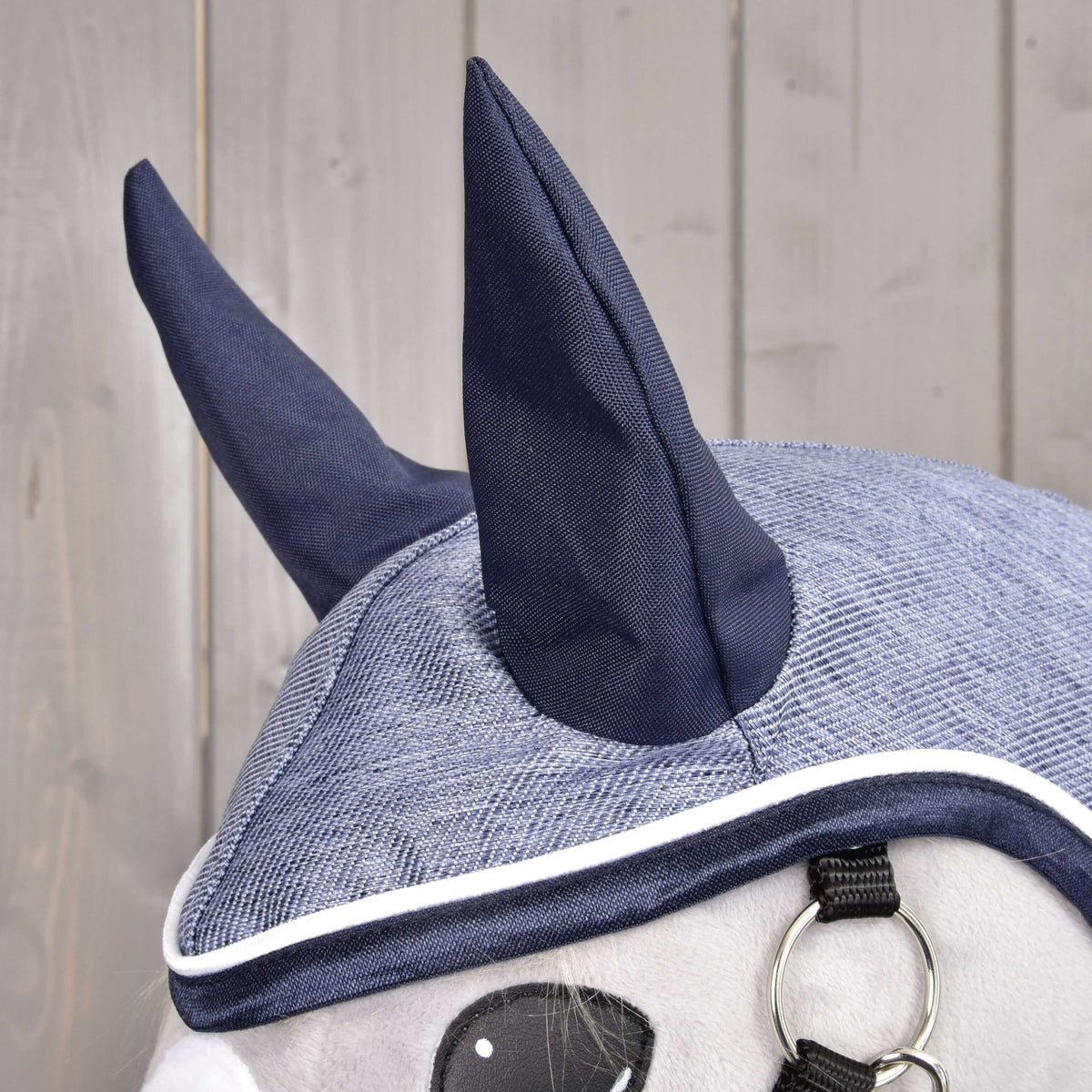 Close-up of the Raincoat Jeans hood with navy ears and a denim-blue crown edged in navy and white