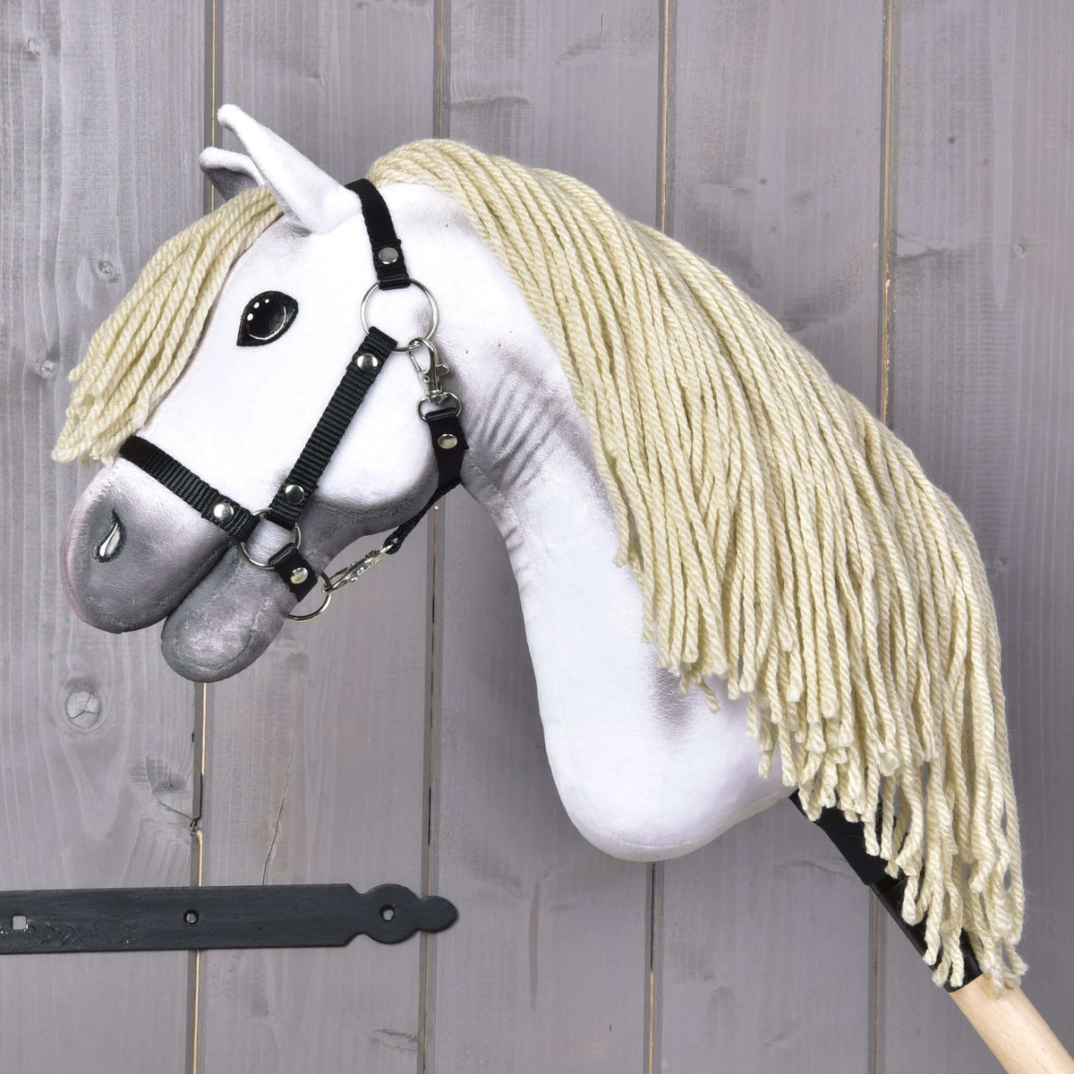Hobby Horse Little Lady med svart grimma med sänkt huvud, tjock krämvit man av garn som hänger ner mot träkäppen