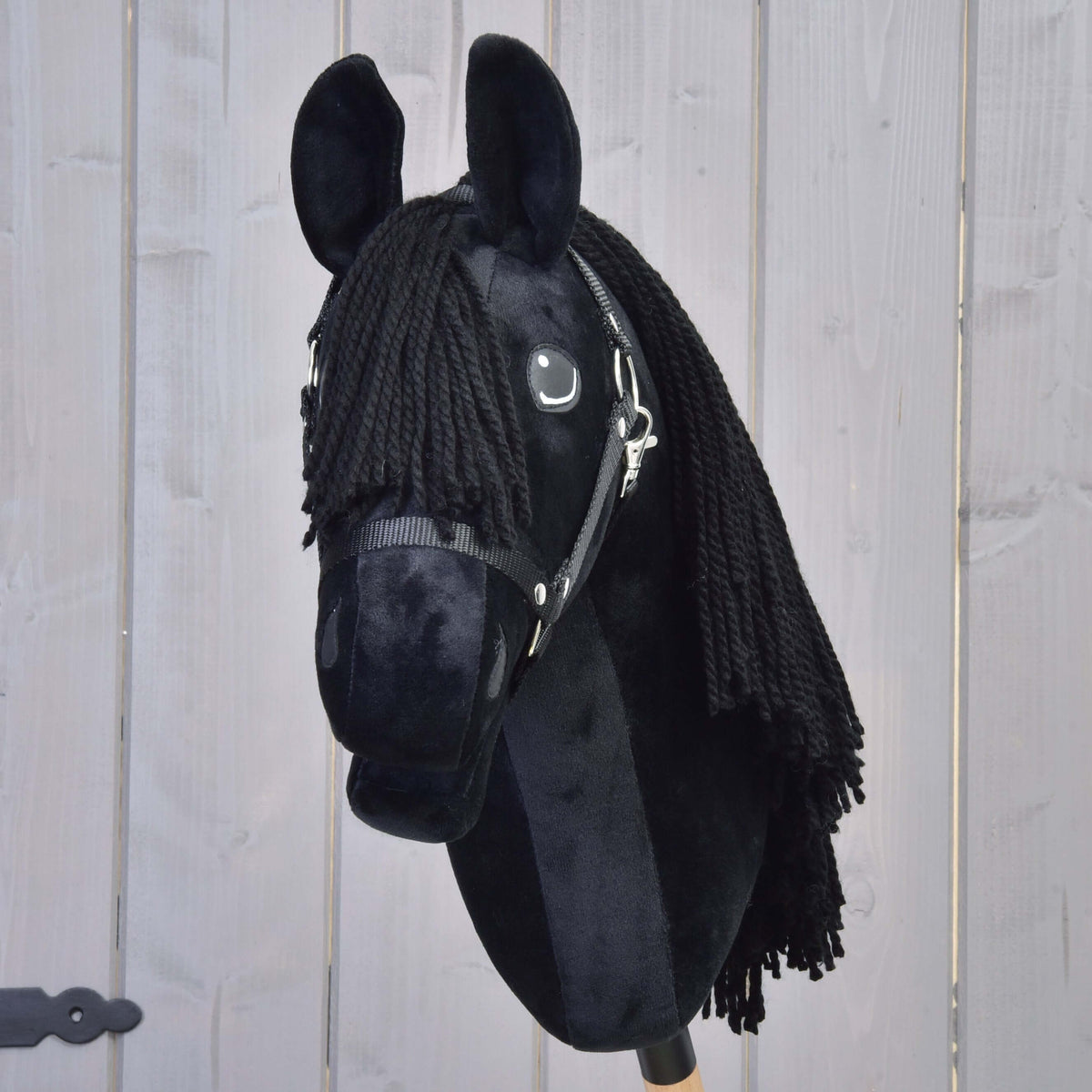 Hobby Horse Mahal med svart grimma framifrån, svart pannlugg av garn mellan upprättstående svarta öron i plysch