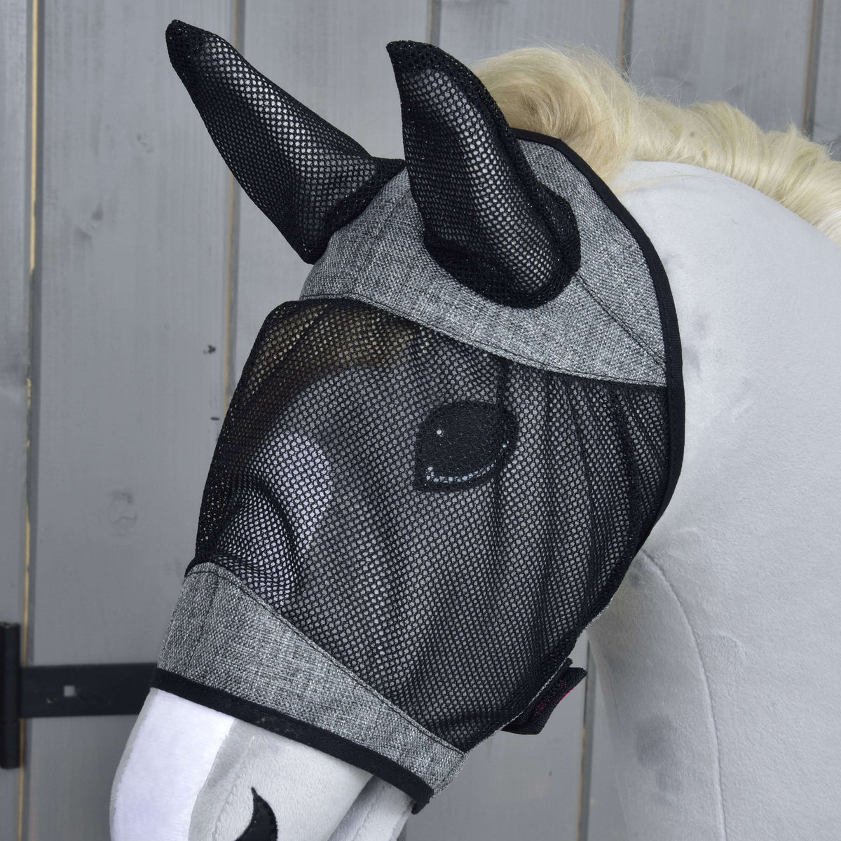 Närbild av flugmasken De Luxe Light Grey på en grå käpphäst, det svarta nätet täcker ögat och båda öronen