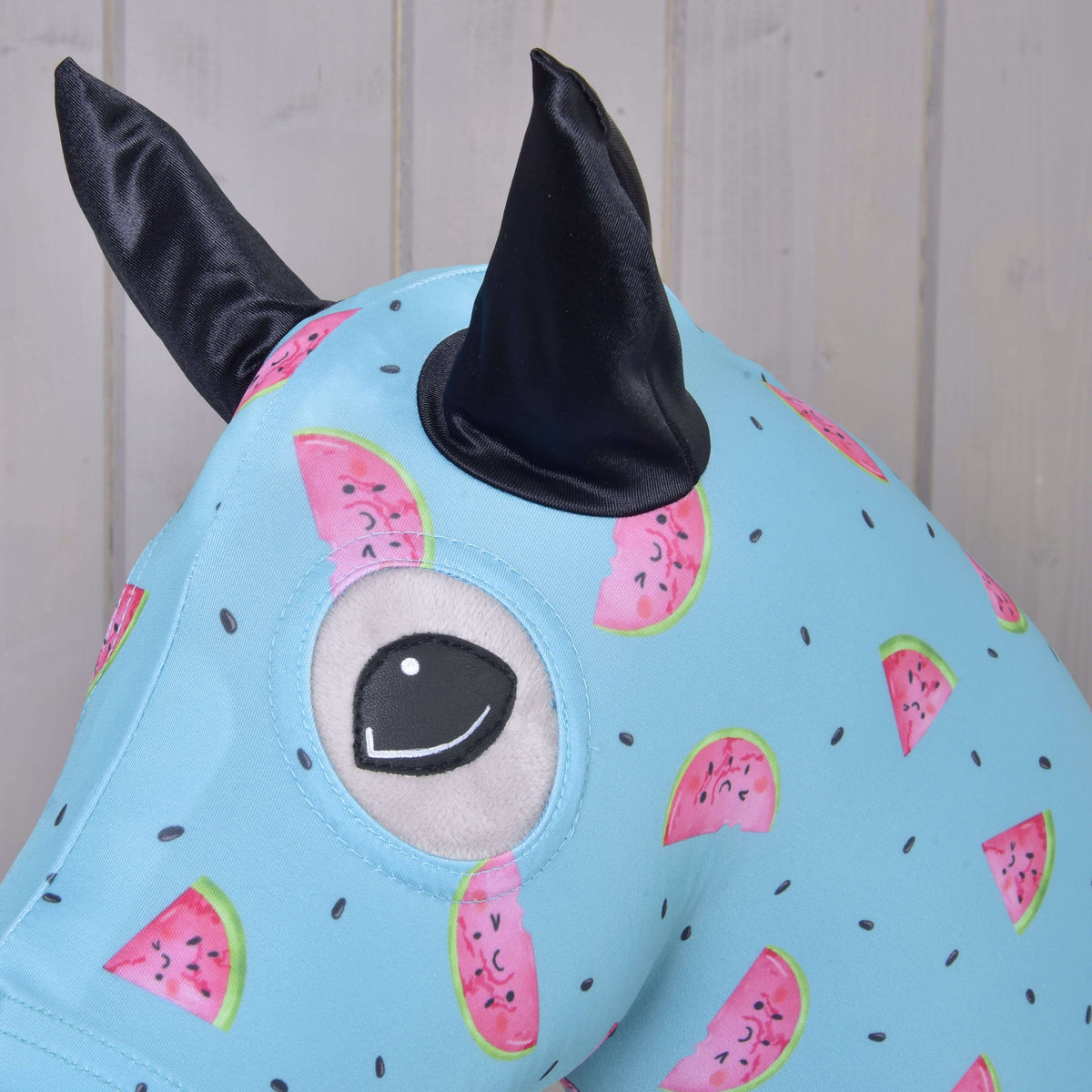 Close-up of the Hobby Horse protective suit Melon: black satin ear and eye opening in the watermelon print
