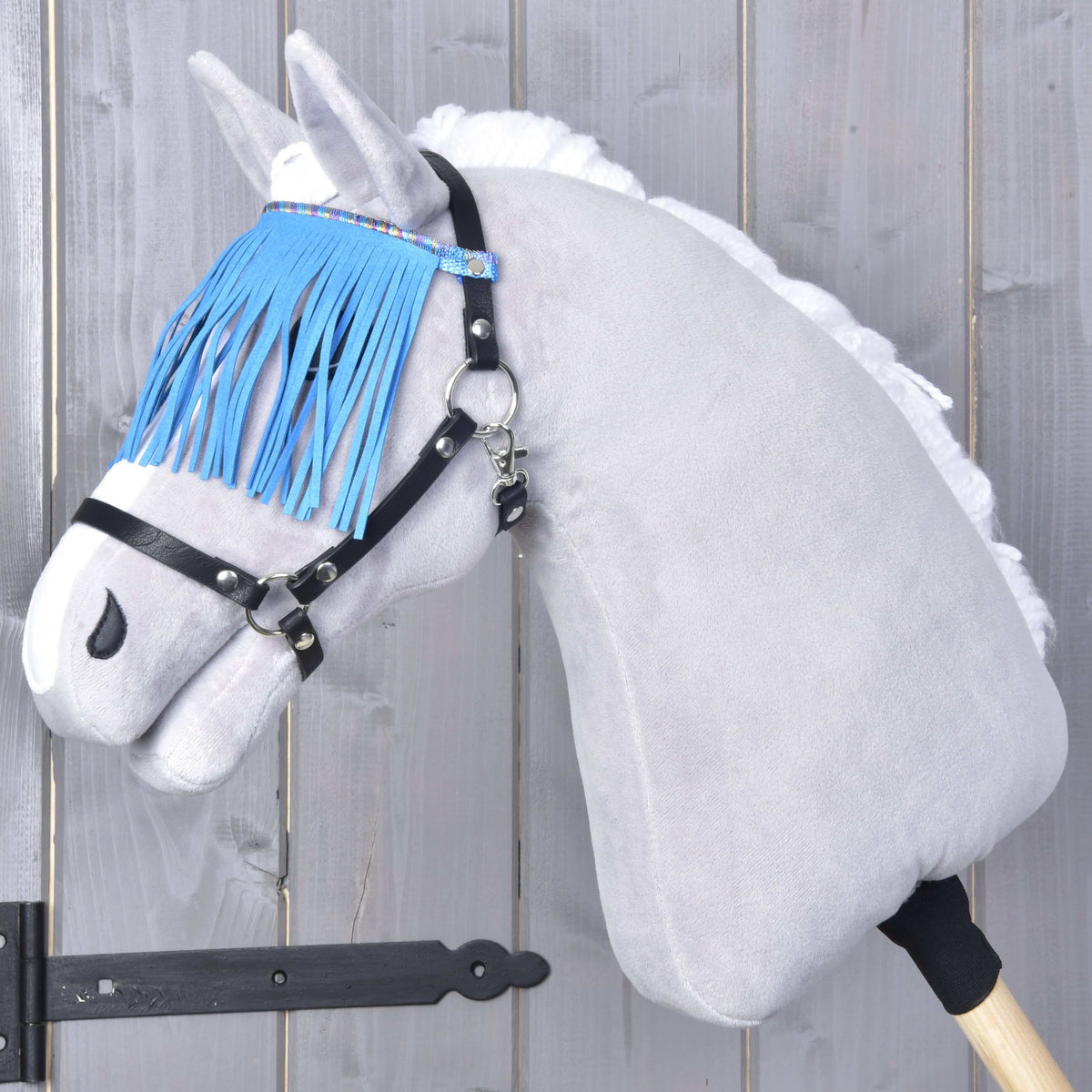Hobby Horse grimma svart med blå fransar från LarDen på ett grått käpphästhuvud i plysch, klarblå fransar faller över ögonen