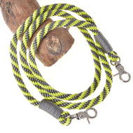 LarDen Hobby Horse Reins Lemon Stripe, lime and grey braided rope reins with silver snap hooks draped over a wooden branch