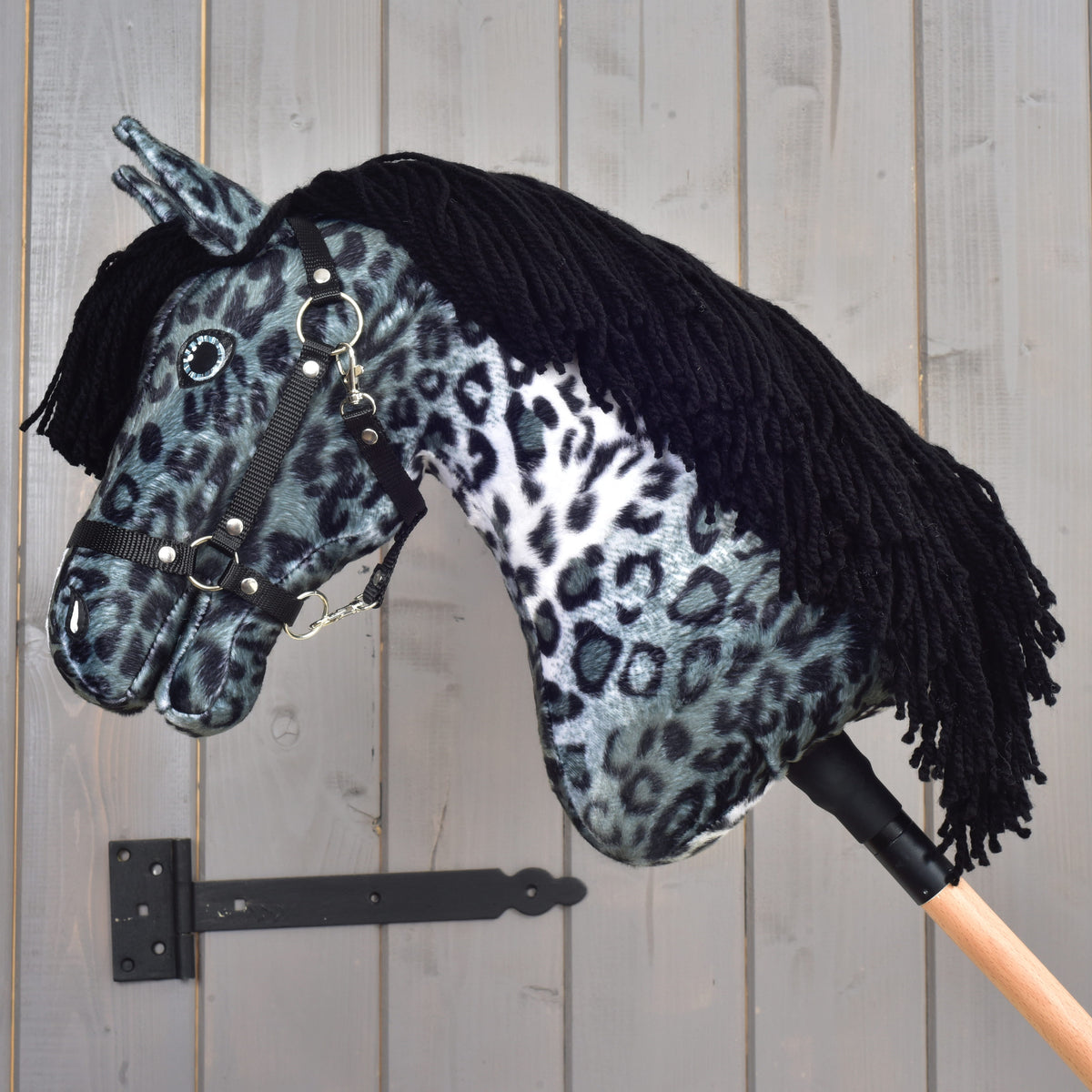 Hobby Horse Picasso with Black Halter in profile with head bowed and the black yarn mane hanging over the neck