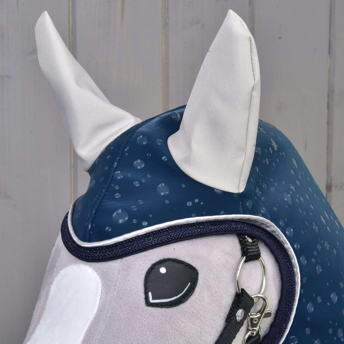 Närbild av huvan på Hobby Horse regntäcke Derby med ljusgrå öron och kant i marinblått och vitt runt ansiktet