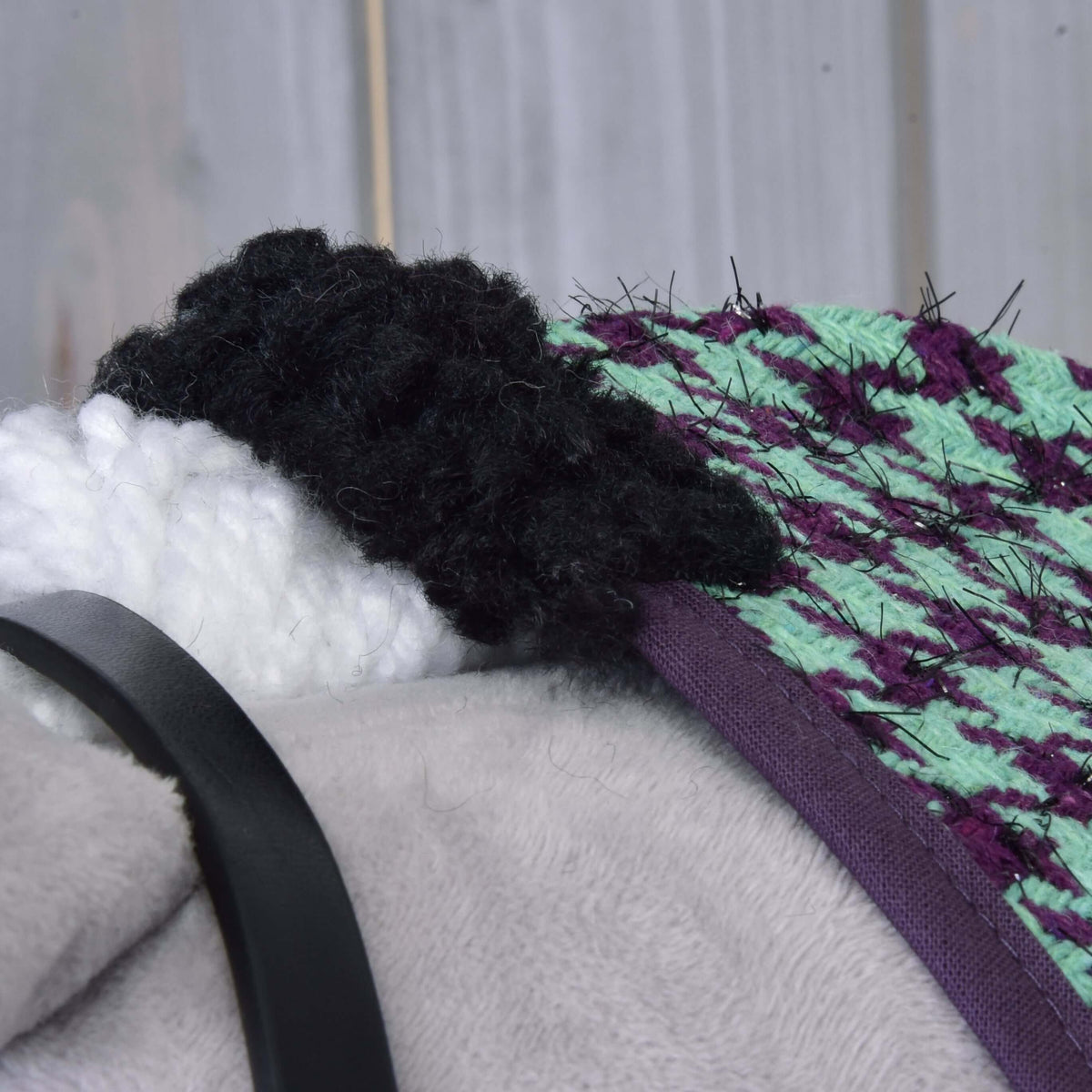 Close-up of the black curly fleece collar and mint and purple houndstooth weave of the Set Harmony Green blanket