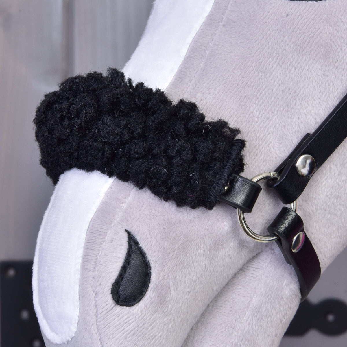 Close-up of the black curly fleece noseband padding of the Set Harmony Pink halter on a grey Hobby Horse