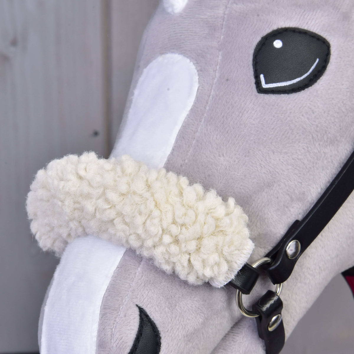 Close-up of the cream curly fleece noseband on the black halter of Set Harmony Victory beside the Hobby Horse eye
