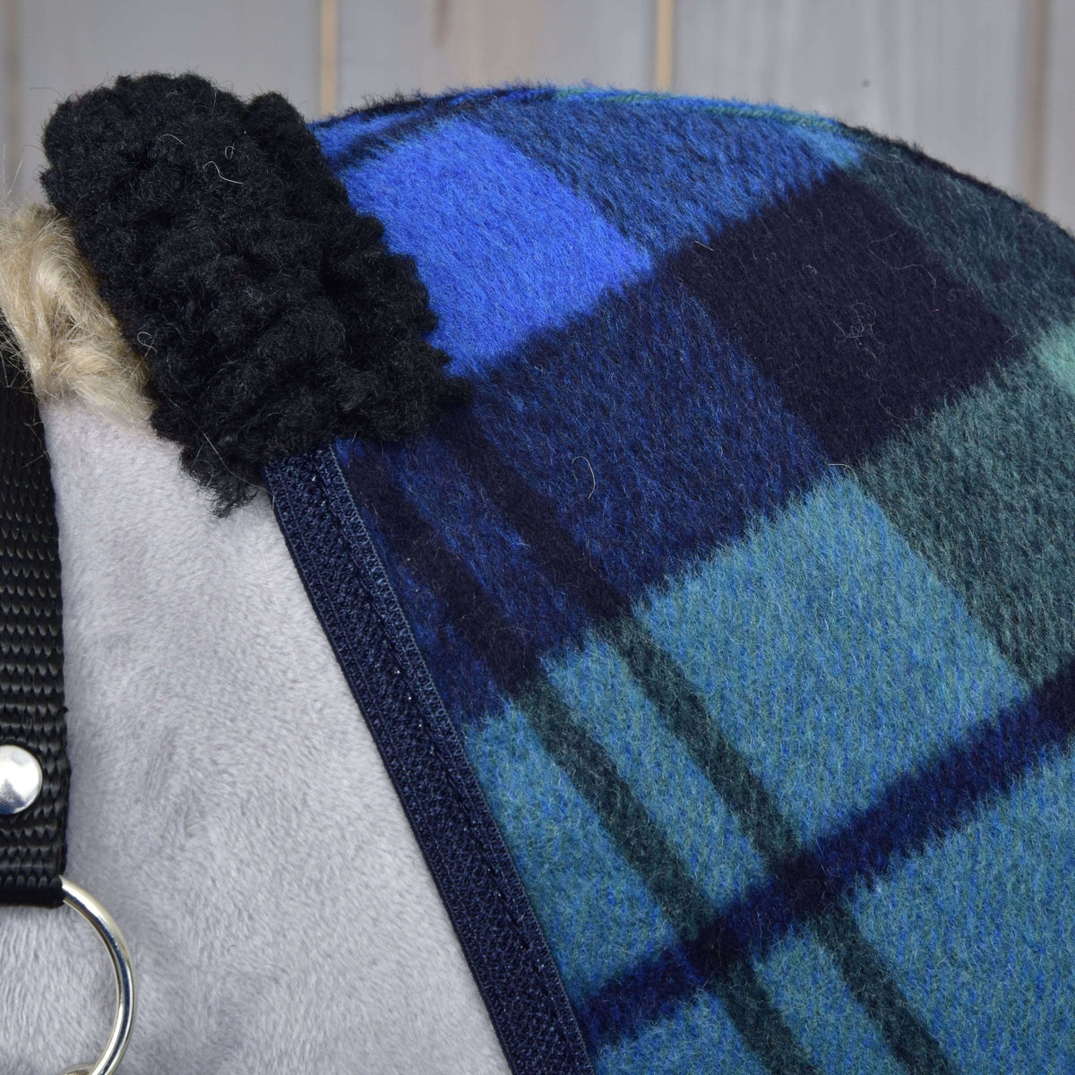 Close-up of the black curly fleece at the withers and the navy binding on the blue and green tartan fleece