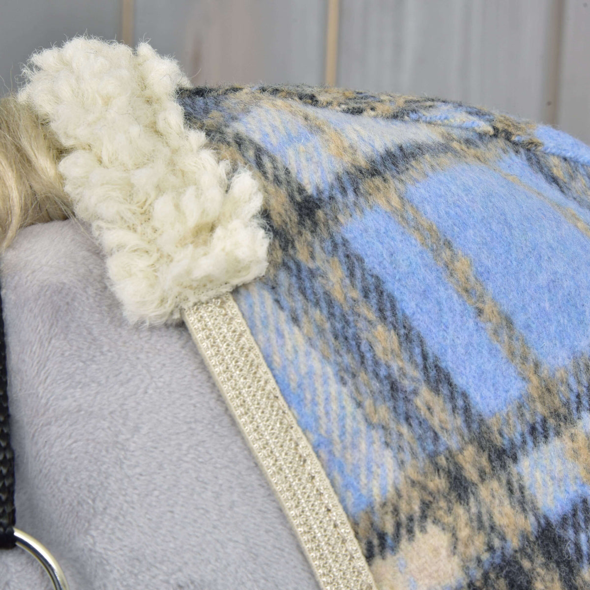 Close-up of the cream curly fleece collar and beige binding on the light blue, beige and charcoal check fleece
