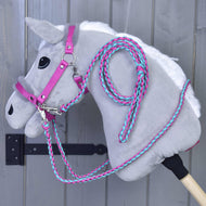 Light grey Hobby Horse wearing the pink fur halter with braided pink and turquoise reins and a coiled lead rope