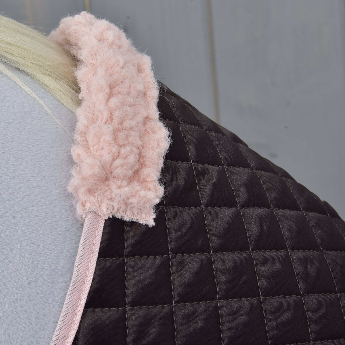 Close-up of the soft pink teddy collar and pink edging on the quilted dark brown blanket of Set Thermo Sweety