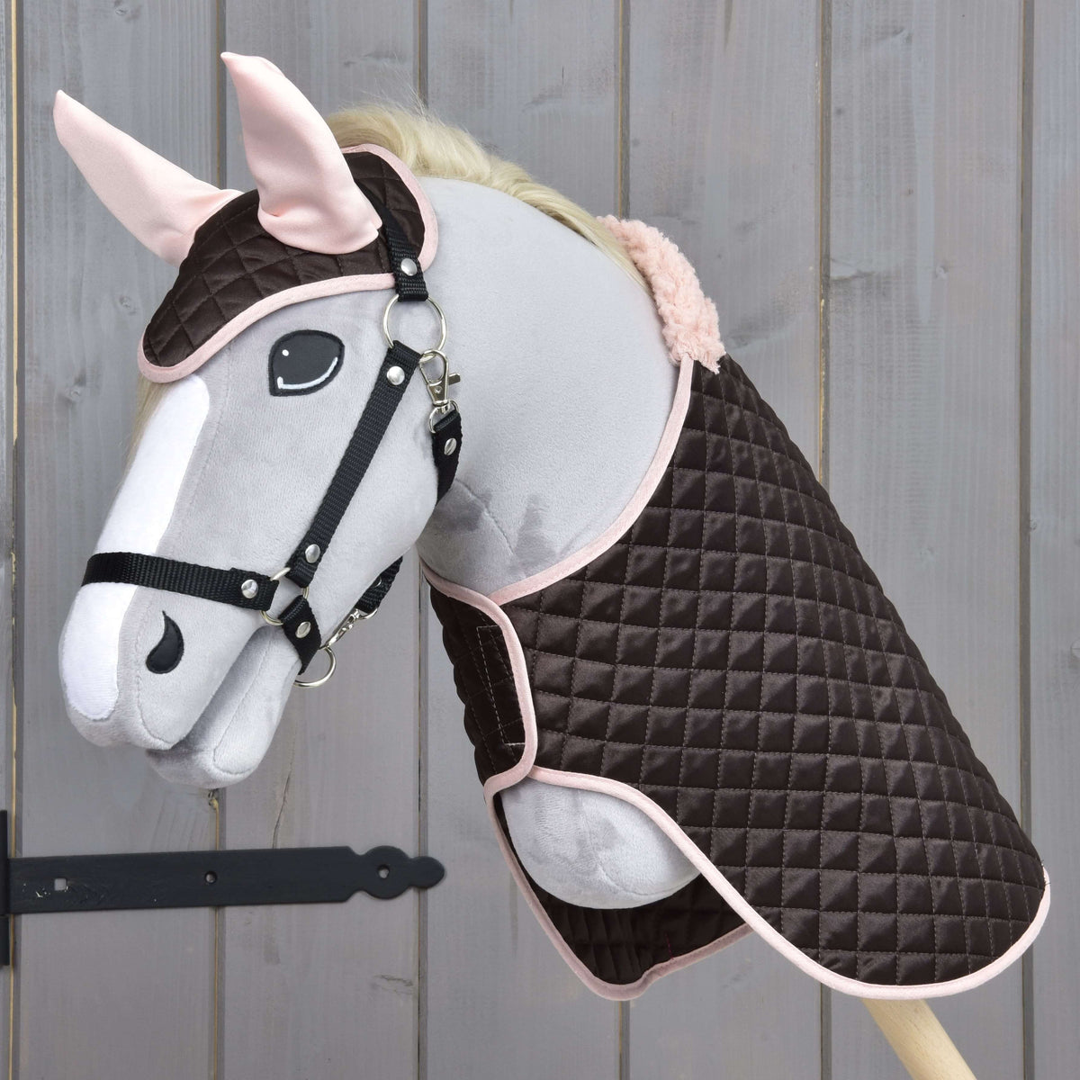 Grey Hobby Horse in a black halter wearing Set Thermo Sweety, the quilted brown blanket and ear bonnet with pink ears