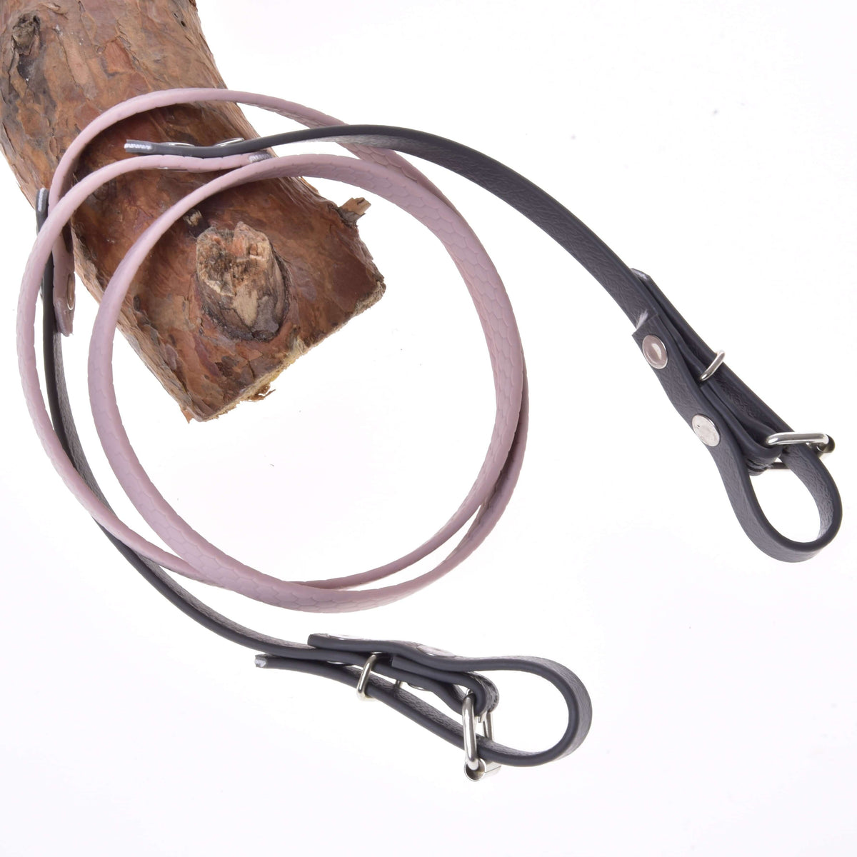Hobby Horse gummerade tyglar Dark Grey/Pink från LarDen, ljusrosa mittparti och mörkgrå ändar med spännen, upphängda över en gren