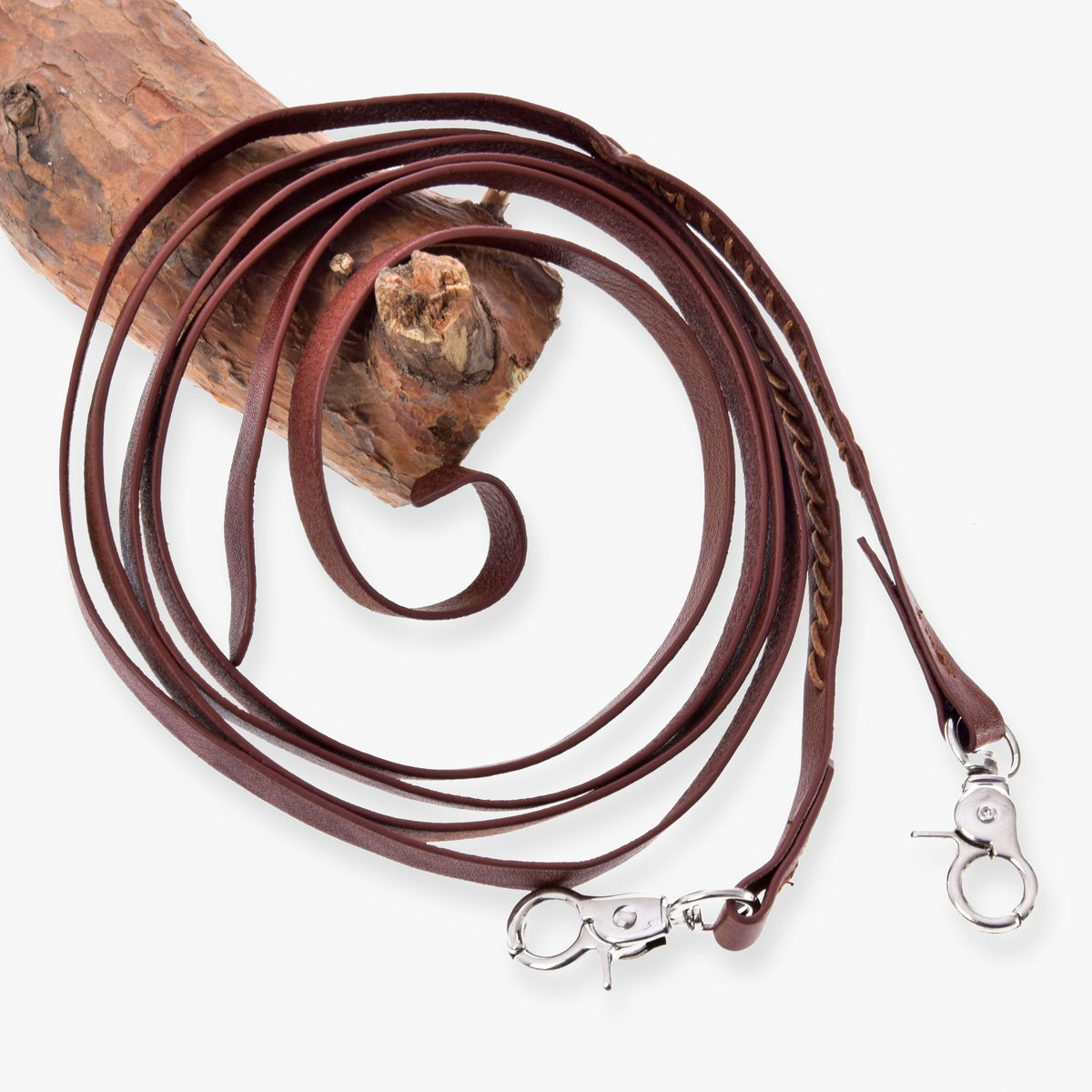 Hobby Horse delade westerntyglar Dark Brown från LarDen med sydda detaljer och två silverfärgade karbinhakar, upprullade över en gren