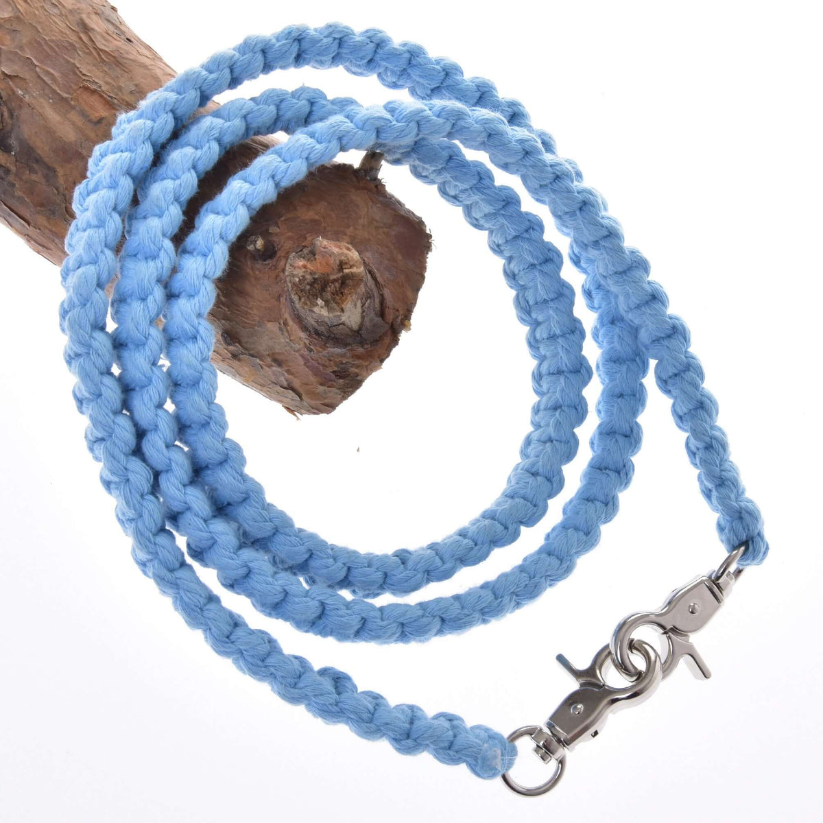 Light blue braided cotton reins for Hobby Horse with two silver snap hooks, draped over a tree branch