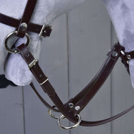 Close-up of the dark brown leatherette martingale with silver rings and the reins on a grey Hobby Horse