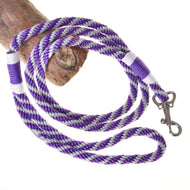 LarDen Hobby Horse Lead Rope Stripe Lila, a purple and silver braided lead with a silver snap hook, coiled over wood